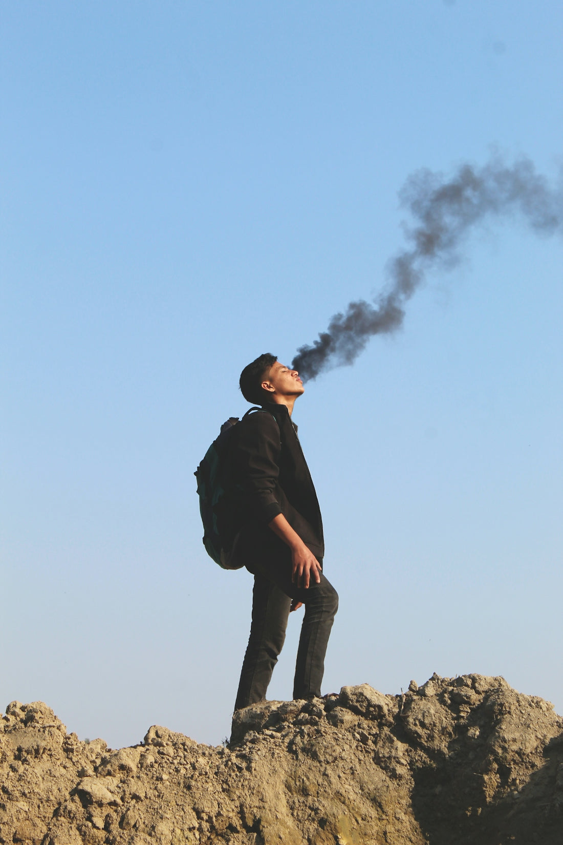 a man standing on top of a rocky hill
