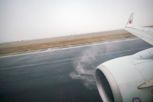 a view of the wing of an airplane on a runway